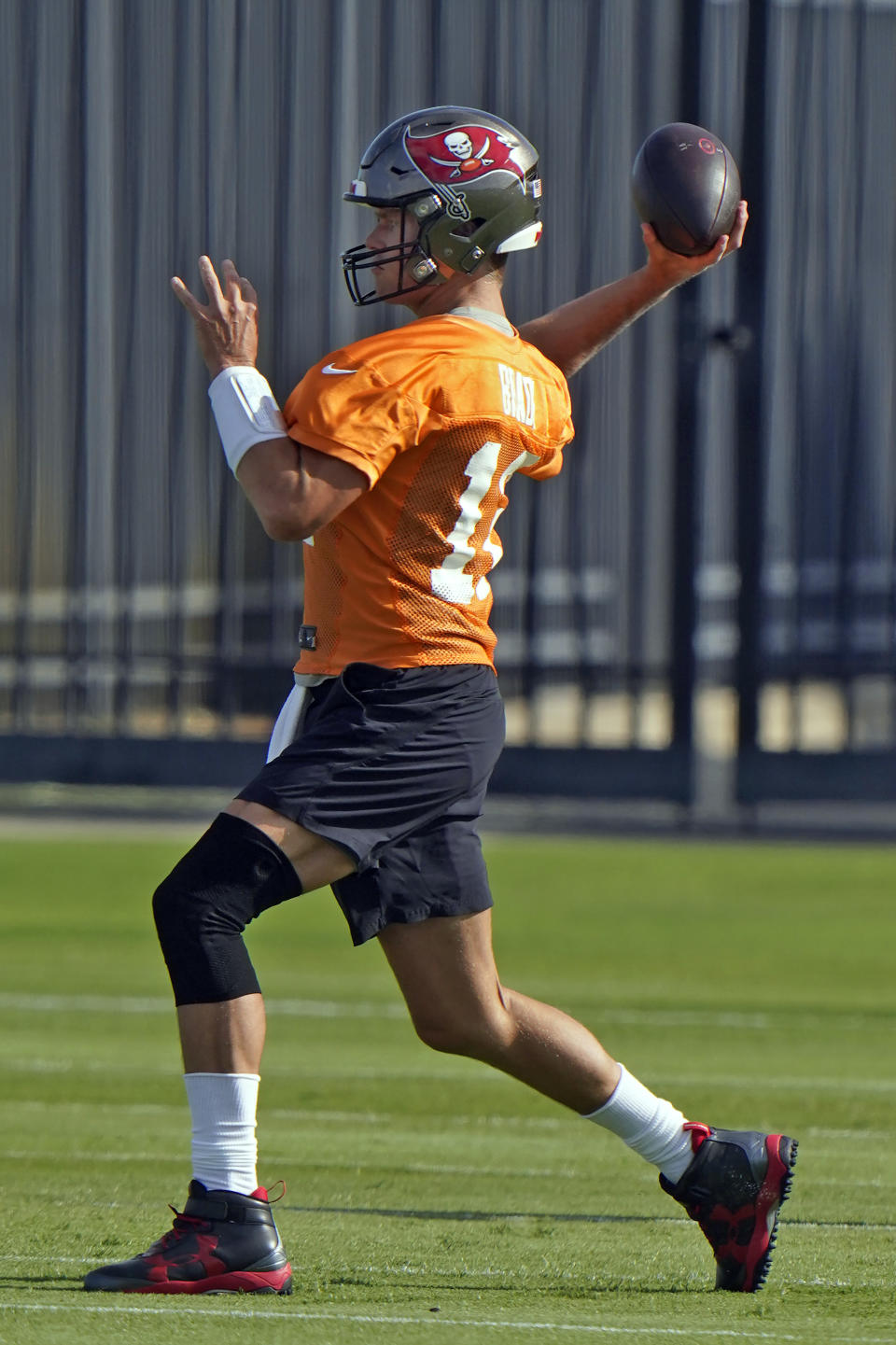 Tampa Bay Buccaneers quarterback Tom Brady wears a knee brace as he throws a pass during an NFL football minicamp Tuesday, June 8, 2021, in Tampa, Fla. (AP Photo/Chris O'Meara)