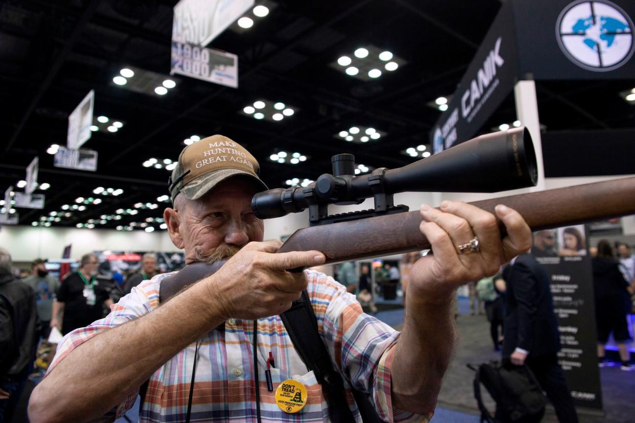<p>Mark McKenzie of Tulsa, Oklahoma, looks through the scope of a deactivated rifle at the 2019 National Rifle Association (NRA) Annual Meetings and Exhibits in Indianapolis, Indiana, on April 26, 2019. </p> ((Photo by SETH HERALD/AFP via Getty Images))