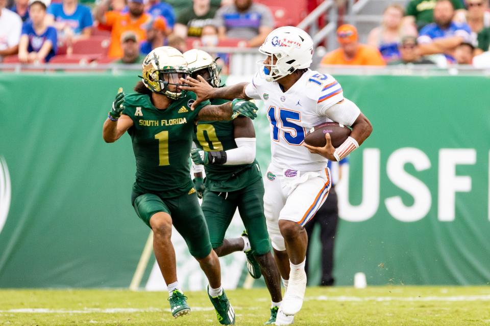 Florida Gators quarterback Anthony Richardson (15) stiff arms <a class="link " href="https://sports.yahoo.com/ncaaw/teams/south-florida/" data-i13n="sec:content-canvas;subsec:anchor_text;elm:context_link" data-ylk="slk:South Florida Bulls;sec:content-canvas;subsec:anchor_text;elm:context_link;itc:0">South Florida Bulls</a> quarterback Jarren Williams (1) during the fourth quarter at Raymond James Stadium in Tampa, FL on Saturday, September 11, 2021. [Matt Pendleton/Special to Sun]