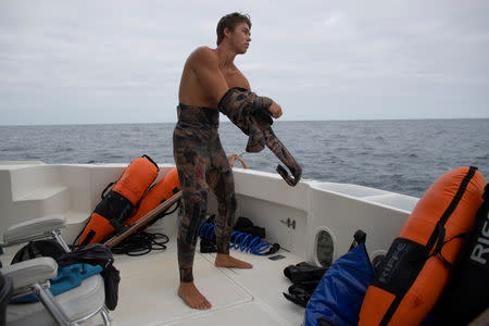 Ryder Devoe, 19, puts on his freediving gear before entering the ocean in search of large Pacific bluefin tuna off the coast of San Diego, California, U.S. September 5, 2018. REUTERS/Mike Blake