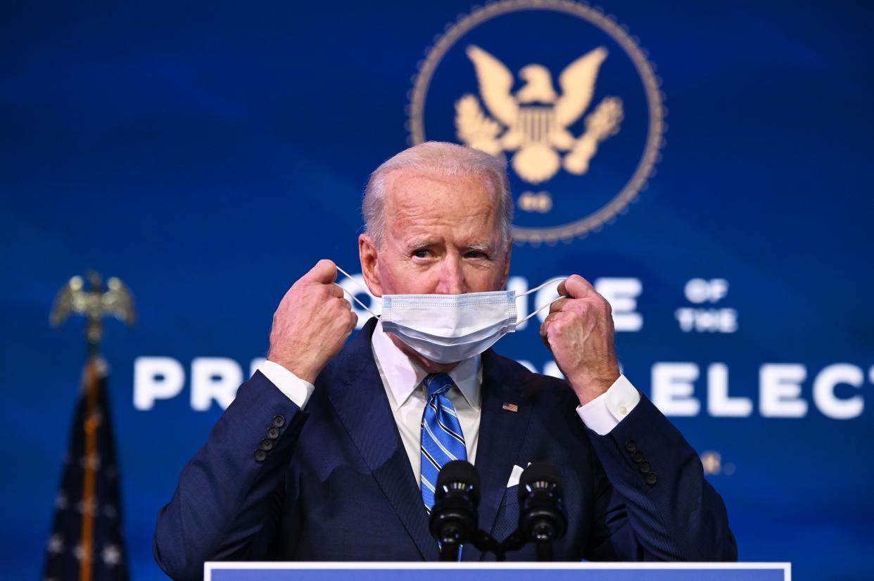 US President-elect Joe Biden removes his facemask before delivering remarks on the public health and economic crises at The Queen theater in Wilmington, Delaware on January 14, 2021. - President-elect Joe Biden will propose injecting $1.9 trillion into the US economy when he takes office next week, as evidence mounts that the recovery from the sharp downturn caused by Covid-19 is flagging. (Photo by JIM WATSON / AFP) (Photo by JIM WATSON/AFP via Getty Images)