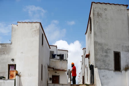 FILE PHOTO: A Sikh migrant worker stands next to his home in Bella Farnia, in the Pontine Marshes, south of Rome. Originally from IndiaÕs Punjab state, the migrant workers pick fruit and vegetables for up to 13 hours a day for between 3-5 euros ($3.30-$5.50) an hour, in Bella Farnia, Italy May 19, 2019. REUTERS/Yara Nardi