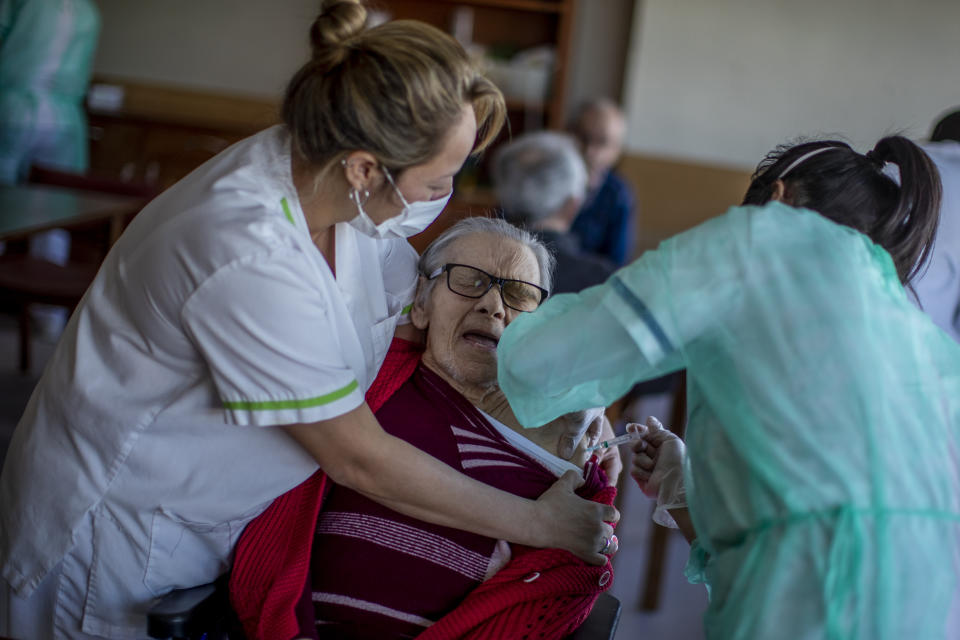 A nurse administers the Pfizer-BioNTech COVID-19 vaccine to a resident at DomusVi nursing home in Leganes, Spain, Wednesday, Jan. 13, 2021. Spain's rate of infection has shot up to 435 cases per 100,000 residents in the past two weeks, prompting new restrictions as authorities try to bring vaccination up to speed. (AP Photo/Manu Fernandez)