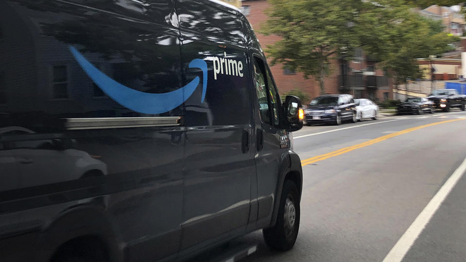 An Amazon delivery truck rolls along a street delivering packages on Friday, Oct. 2, 2020, in Boston. (AP Photo/Bill Sikes)
