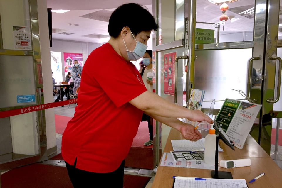 Image: A woman sanitizes her hands before going into a sports center in Taipei. Hand sanitizers are made available in many buildings and businesses in Taiwan. (Cindy Sui / NBC News)