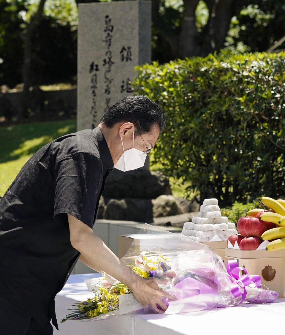 Japan's Prime Minister Fumio Kishida offers a bouquet of flowers in front of a memorial at the Peace Memorial Park in Itoman, Okinawa, southern Japan Thursday, June 23, 2022. Japan marked the Battle of Okinawa, one of the bloodiest battles of World War II fought on the southern Japanese island, which ended 77 years ago, Thursday. (Kyodo News via AP)