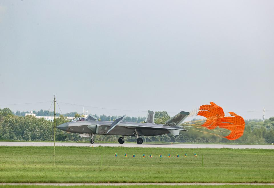 A J-20 stealth fighter jet deploys orange parachutes on on the runway during the 2023 Changchun Air Show.