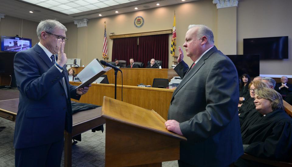 Washington County Circuit Court Clerk Kevin Tucker, left, gives the oath of office to Kirk C. Downey as Downey is sworn in as associate circuit court judge during a ceremony Friday in the Washington County Courthouse in downtown Hagerstown.