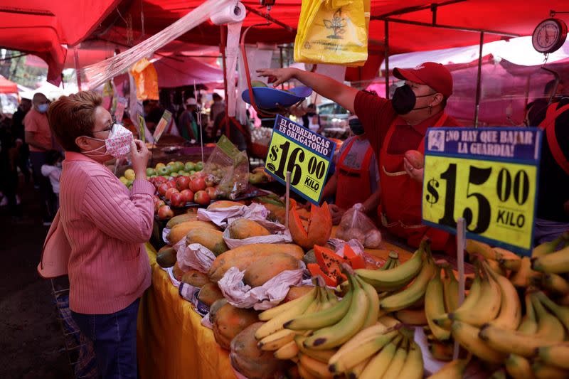 IMAGEN DE ARCHIVO. Un vendedor conversa con una clienta en un puesto en un mercado en en Ciudad de México, México