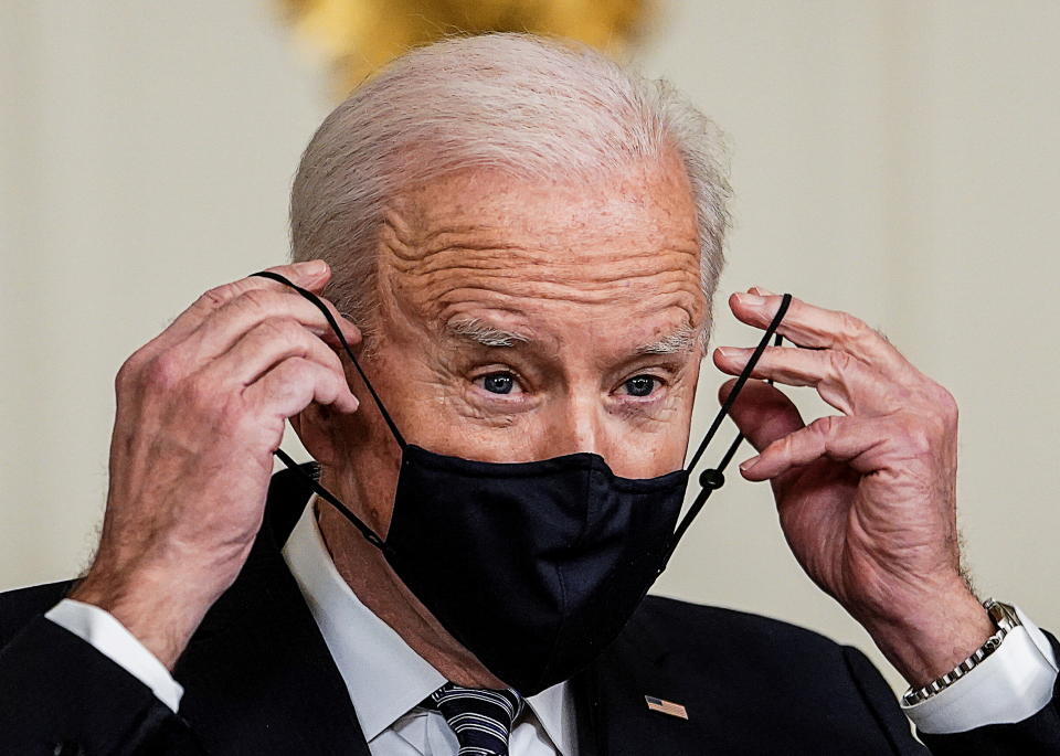 U.S. President Joe Biden replaces his face mask after delivering remarks on the implementation of the American Rescue Plan in the State Dining Room at the White House in Washington, U.S., March 15, 2021. REUTERS/Kevin Lamarque     TPX IMAGES OF THE DAY