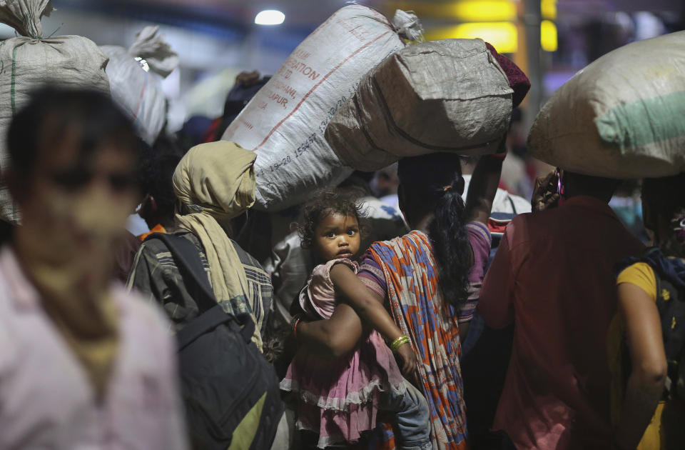 FILE - In this Saturday, May 23, 2020, file photo, migrant workers line up to board trains to their home states at a railway station in Hyderabad, India. The head of India's massive railway system said Friday, May 29, that authorities are investigating whether some migrant workers died of starvation or sickness this week while traveling on special trains to their home villages in blazing heat after losing their jobs in cities because of the coronavirus lockdown. Railway Board Chairman Vinod Kumar Yadav said more than 5 million migrant workers and their families this month from cities and towns to their home villages on 3,840 trains. (AP Photo/Mahesh Kumar A., File)