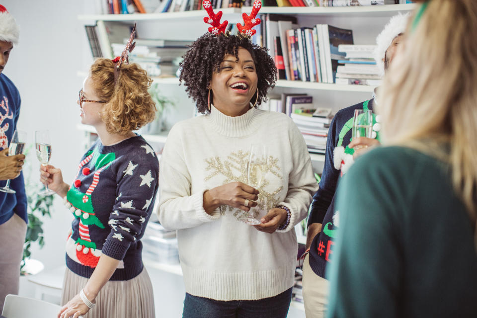 Colleagues celebrating Christmas in the office, wearing festive jumpers. (Getty Images)