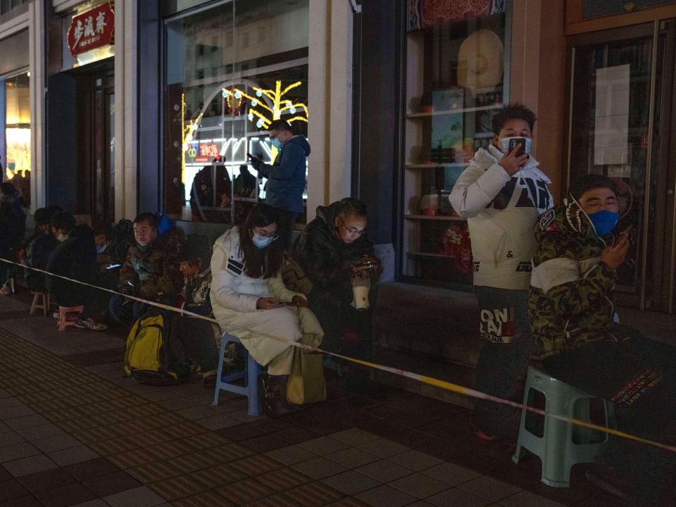 People line up along the darkened Wangfujing pedestrian mall outside the Gongmei Emporium to queue overnight for a chance to buy the 2022 Winter Olympics mascot Bing Dwen Dwen in Beijing on Tuesday, Feb. 8, 2022. A long line has persisted in the past days to snap up scarce 2022 Winter Olympic souvenirs, especially stuffed versions of Games mascot Bing Dwen Dwen, a panda in a winter coat.