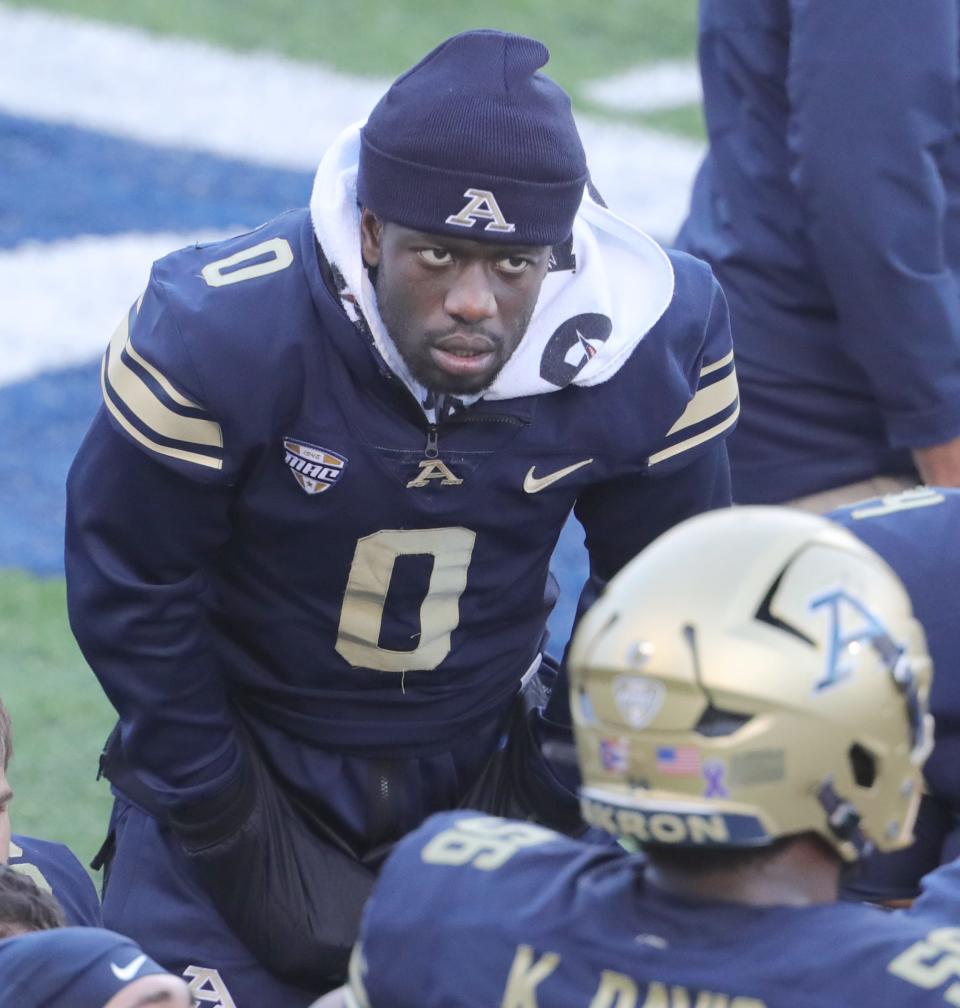 Injured University of Akron quarterback DJ Irons listens to a conversation on the sidelines during the second quarter against NIU on Saturday in Akron.