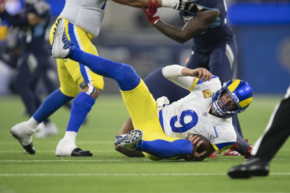 Rams quarterback Matthew Stafford (9) falls on the ground after being tackled by the Titans.