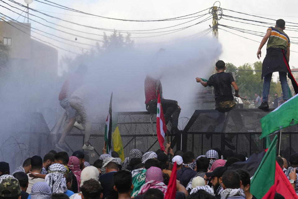 Riot police spray protesters with a water cannon during a demonstration in solidarity with the Palestinian people in Gaza, near the U.S. embassy in Aukar, a northern suburb of Beirut, Lebanon, Wednesday, Oct. 18, 2023. (AP Photo/Bilal Hussein)