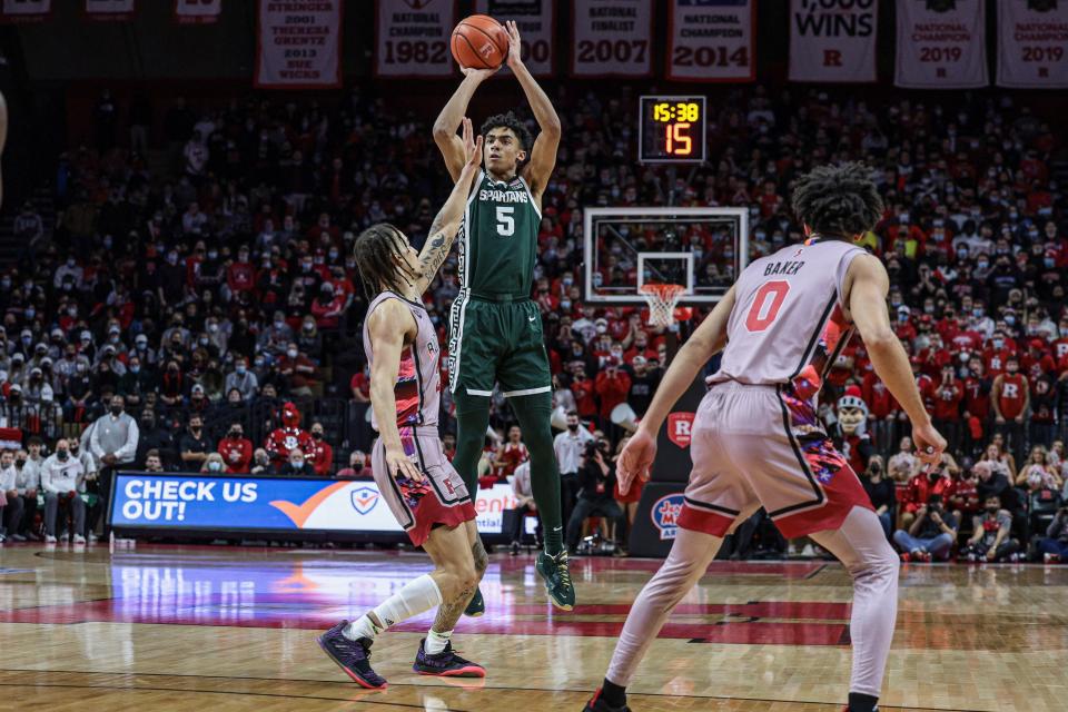 Michigan State Spartans guard Max Christie (5) shoots the ball as Rutgers Scarlet Knights guard Caleb McConnell (22) and guard Geo Baker (0) defend during the first half Feb. 5, 2022 at Jersey Mike's Arena.