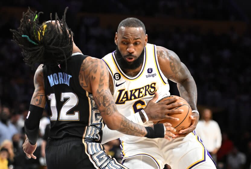 Los Angeles, California April 22, 2023-Lakers LeBron James runs through Grizzlies Ja Morant to score a basket in the third quarter in Game 3 of the first round of the NBA playoffs at Crypto.com arena Saturday. (Wally Skalij/Los Angeles Times)