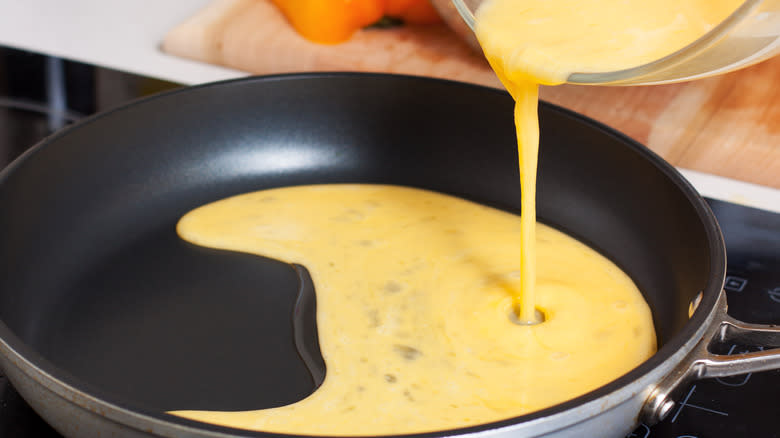 Pouring eggs into skillet