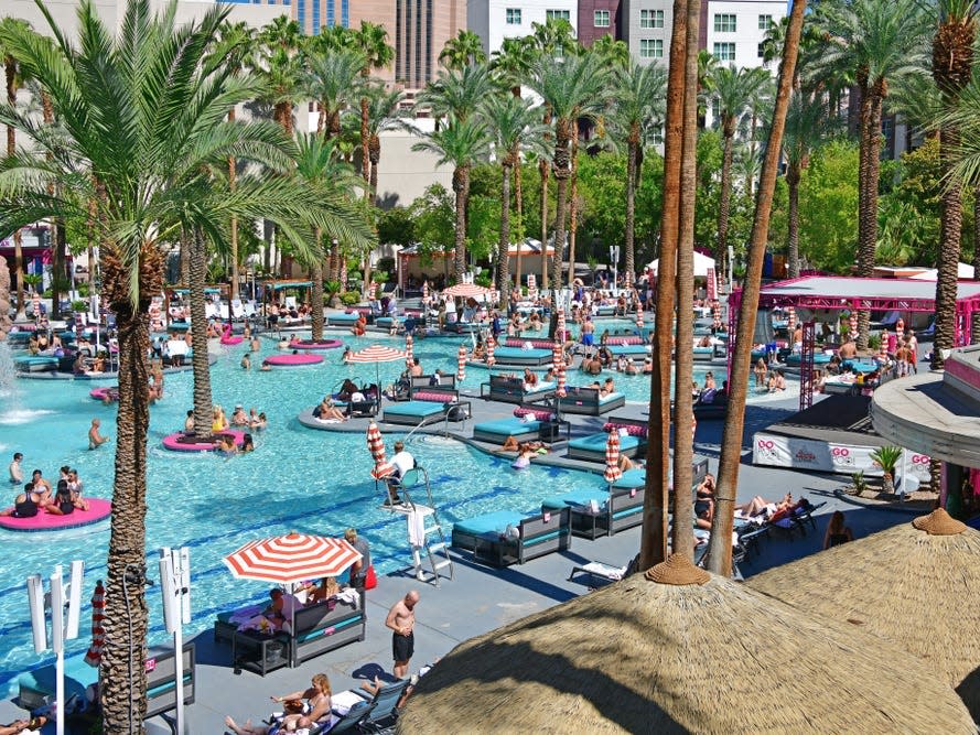 Crowded pool filled with people and palm trees at las vegas resort