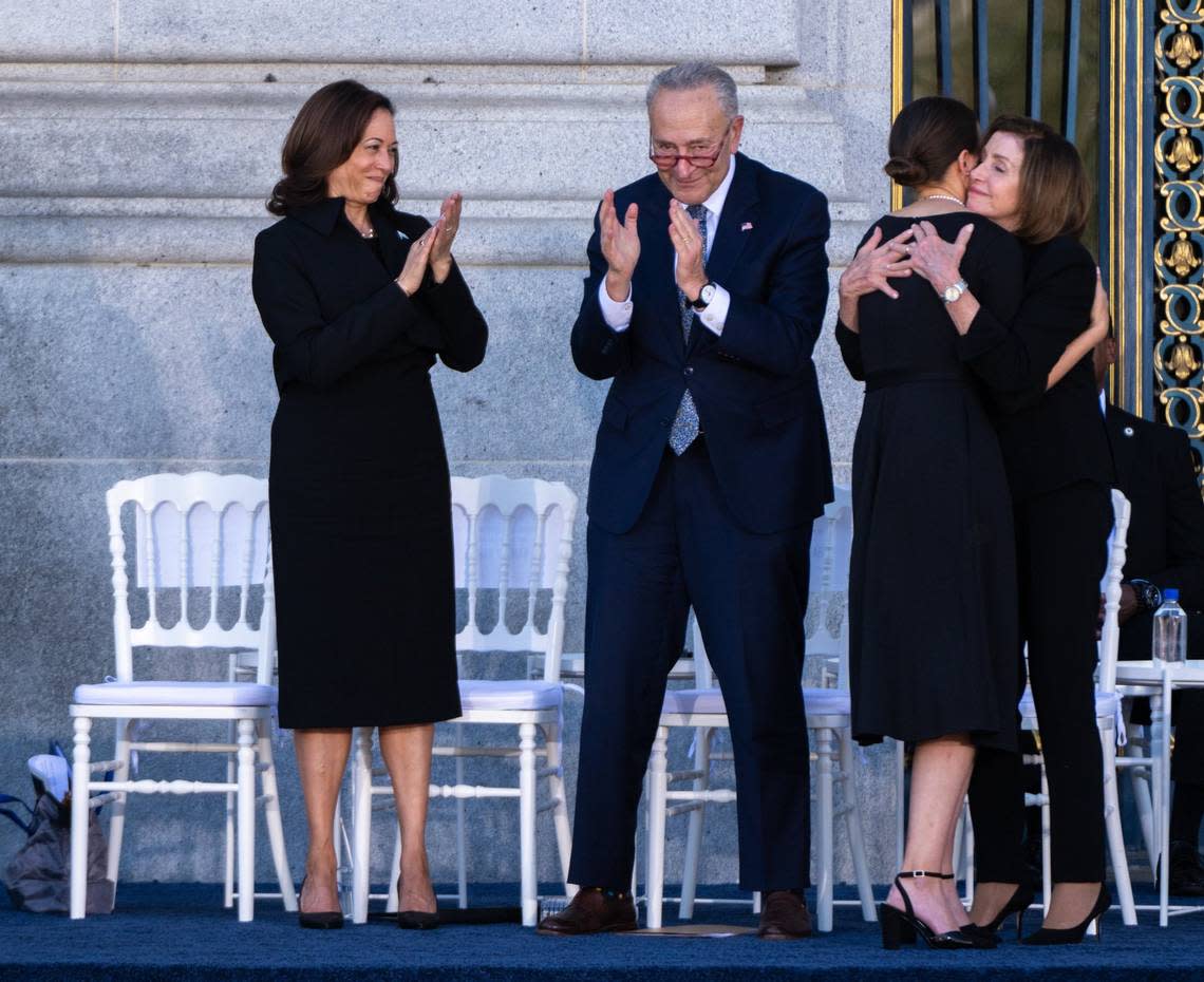 Eileen Mariano, granddaughter of Sen. Dianne Feinstein, hugs House Speaker Emerita Nancy Pelosi as Vice president Kamala Harris and Senate Majority Leader Chuck Schumer applaud during Feinstein’s memorial service at San Francisco City Hall on Thursday.