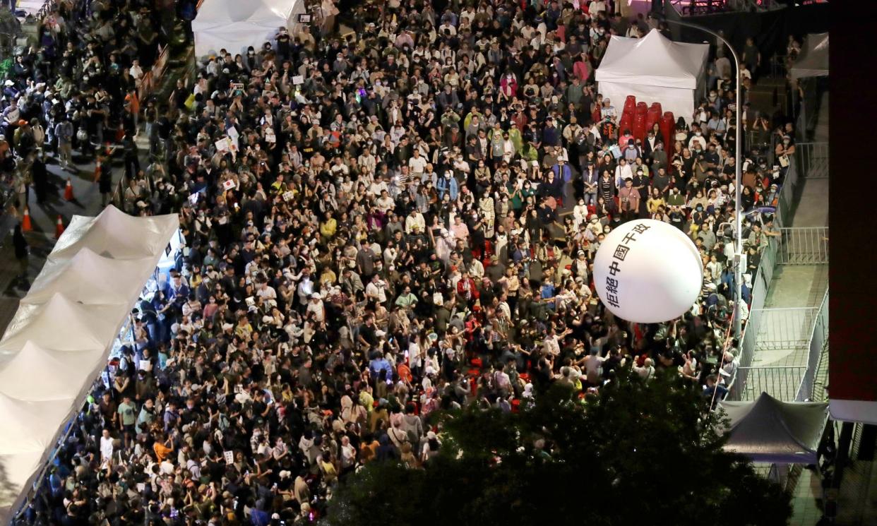 <span>Supporters of the ruling Democratic Progressive party (DPP) hold up a ball on which is printed: ‘Reject China's interference In politics’.</span><span>Photograph: Chiang Ying-ying/AP</span>