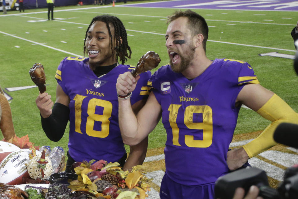 Minnesota Vikings wide receiver Justin Jefferson (18) and wide receiver Adam Thielen (19) eat turkey legs before being interviewed after an NFL football game against the New England Patriots, Thursday, Nov. 24, 2022, in Minneapolis. The Vikings won 33-26. (AP Photo/Andy Clayton-King)