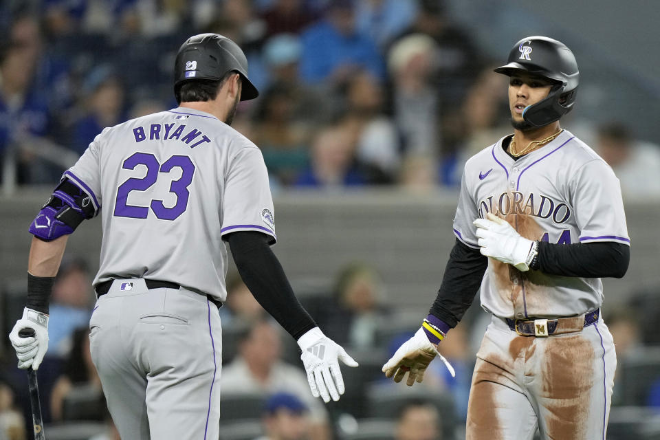 Colorado Rockies' Elehuris Montero, right, is congratulated by teammate Kris Bryant (23) during third-inning baseball game action against the Toronto Blue Jays in Toronto, Friday, April 12, 2024. (Frank Gunn/The Canadian Press via AP)