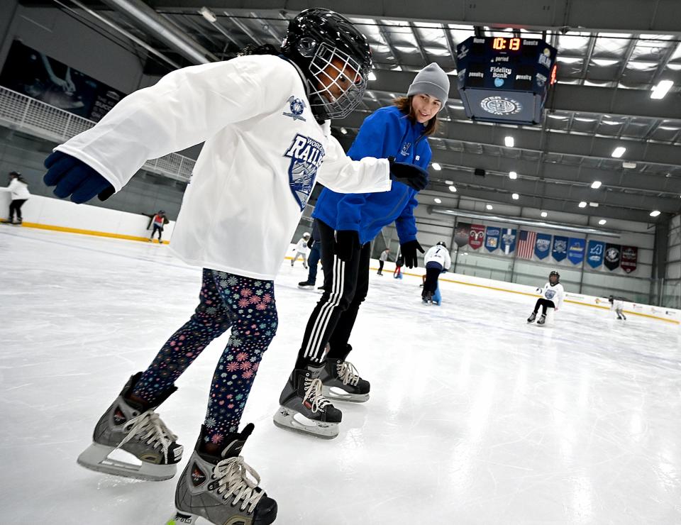 City View Elementary School fourth grader Karrisa Mensah tries out ice skating Tuesday as volunteer Madi Dufries of Leicester, a graphic designer from Mastermans, keeps an eye on her during Worcester Railers' Skate to Success program at the Worcester Ice Center.