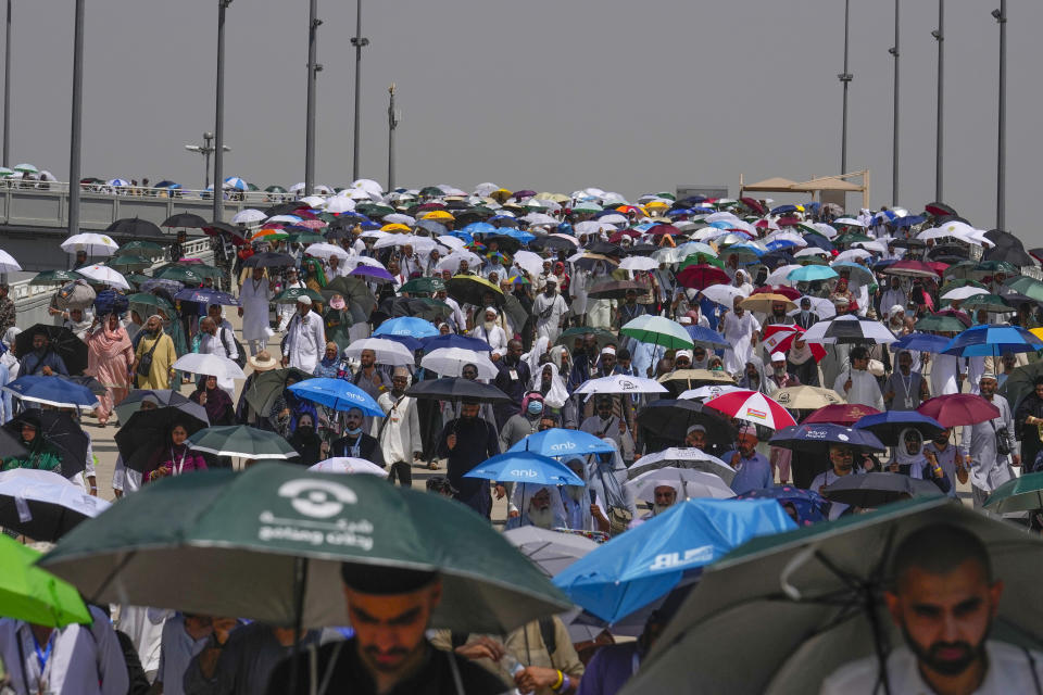 Muslim pilgrims use umbrellas to shield themselves from the sun as they arrive to cast stones at pillars in the symbolic stoning of the devil, the last rite of the annual hajj, in Mina, near the holy city of Mecca, Saudi Arabia, Tuesday, June 18, 2024. Muslim pilgrims were wrapping up the Hajj pilgrimage in the deadly summer heat on Tuesday with the third day of the symbolic stoning of the devil, and the farewell circling around Kaaba in Mecca's Grand Mosque. (AP Photo/Rafiq Maqbool)