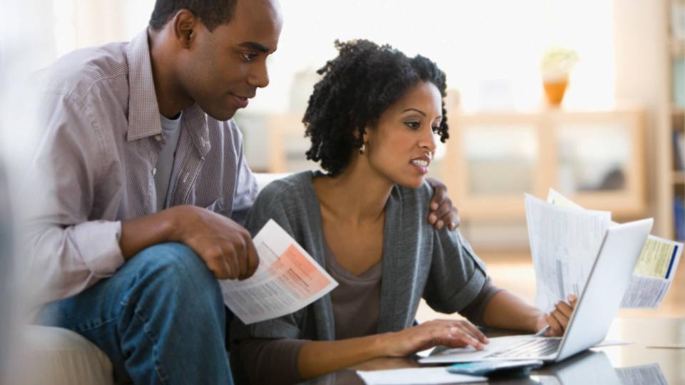 Couple paying bills using laptop.