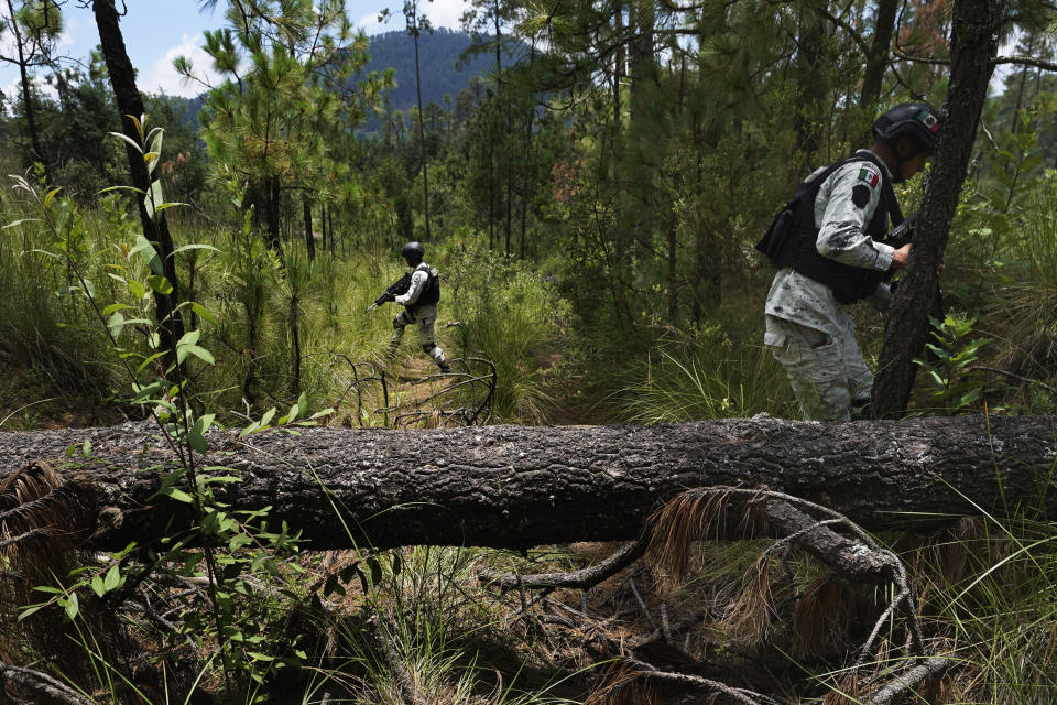 ARCHIVO - Elementos de la Guardia Nacional protegen a agricultores mientras estos plantan pinos el 13 de agosto de 2023 en un área deforestada recientemente, en el pueblo de San Miguel Topilejo, al sur de la Ciudad de México. La tala ilegal es especialmente aguda en este pueblo, el cual, debido a que tiene bosques y es atravesado por carreteras, es un sitio atractivo para que grupos delictivos talen troncos y los lleven a aserraderos. (AP Foto/Marco Ugarte, archivo)