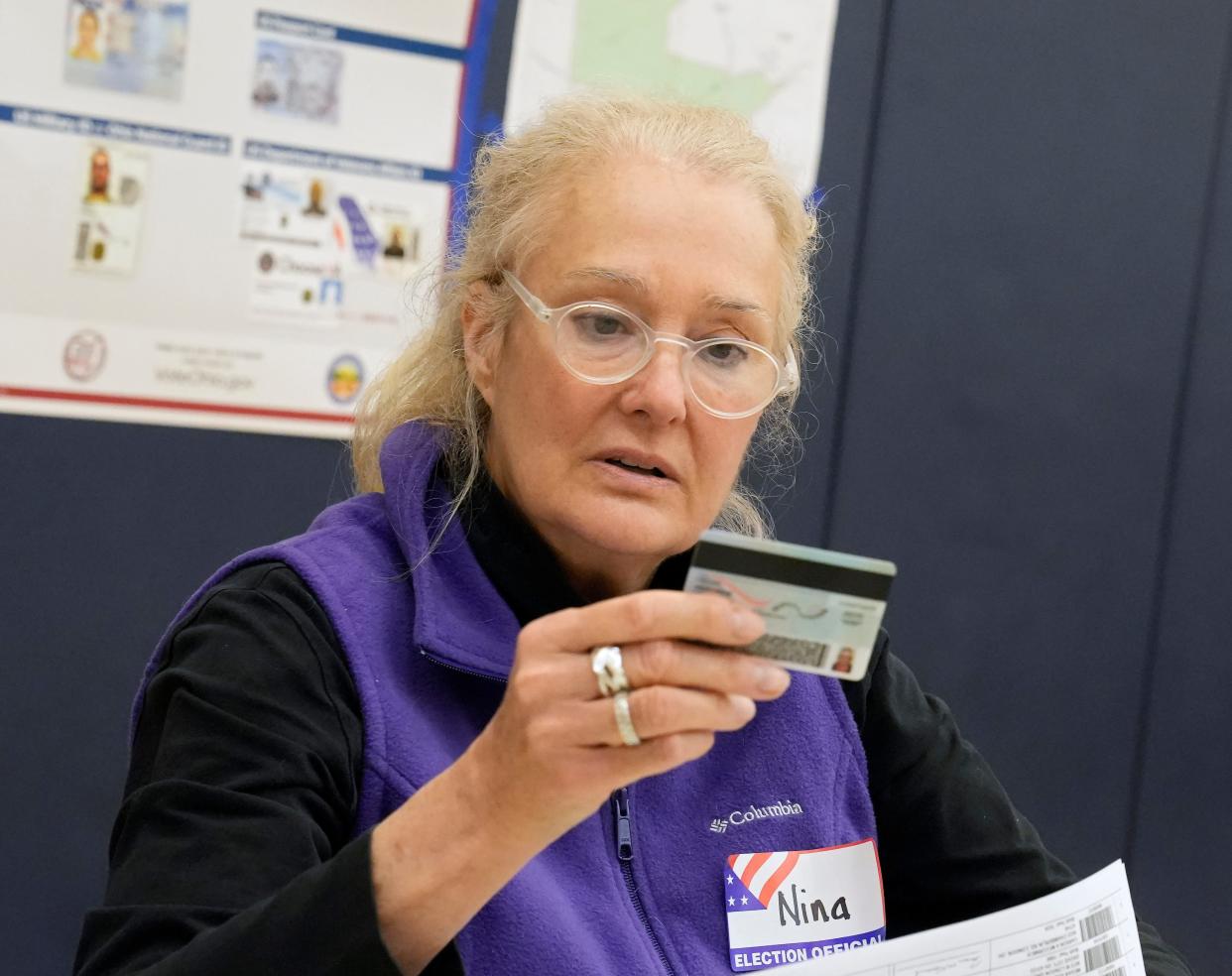 Poll worker Nina Roslovic, 66, of Grandview checks a drivers license at Darbydale Elementary in Grove City on Tuesday.