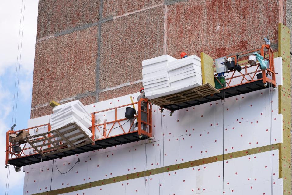 Reducción de la pérdida de calor en un edificio mediante el aislamiento de la pared con losas de lana mineral y poliestireno expandido. <a href="https://www.shutterstock.com/es/image-photo/reduction-heat-loss-multistorey-building-workers-2189689003" rel="nofollow noopener" target="_blank" data-ylk="slk:Shutterstock / ROMAN DZIUBALO;elm:context_link;itc:0;sec:content-canvas" class="link ">Shutterstock / ROMAN DZIUBALO</a>