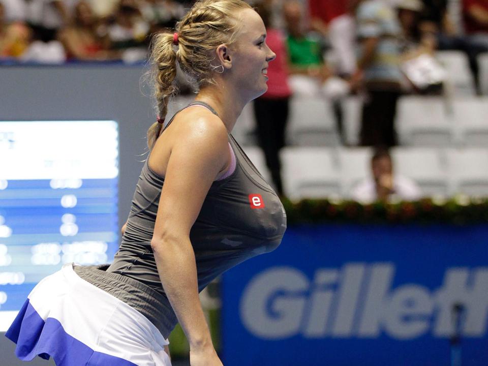 Caroline Wozniacki plays an exhibition with towels stuffed into her shirt and skirt in an apparent Serena Williams imitation.