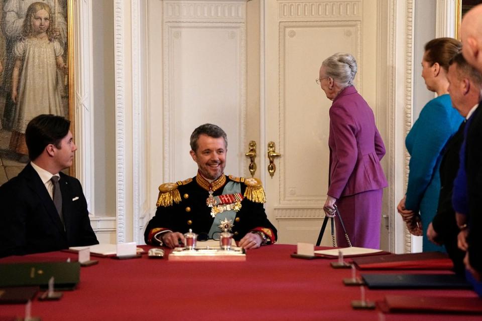 After signing the declaration of abdication Queen Margrethe II of Denmark (C-R) leaves the seat at the head of the table to her son King Frederik X of Denmark (-L) as Prince Christian of Denmark (L) and Danish Prime Minister Mette Frederiksen (R) react during the meeting of the Council of State at the Christiansborg Castle (Ritzau Scanpix/AFP via Getty Ima)