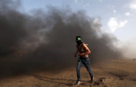 A demonstrator runs during a protest where Palestinians demand the right to return to their homeland, at the Israel-Gaza border in the southern Gaza Strip May 25, 2018. REUTERS/Ibraheem Abu Mustafa