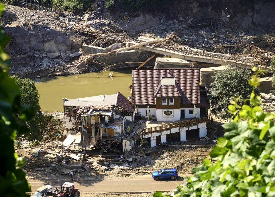 A house is completely torn open after the flood, behind it a destroyed bridge can be seen in Marienthal, Germany, Wednesday, July 21, 2021. The flood has also destroyed numerous houses here. (Thomas Frey/dpa via AP)