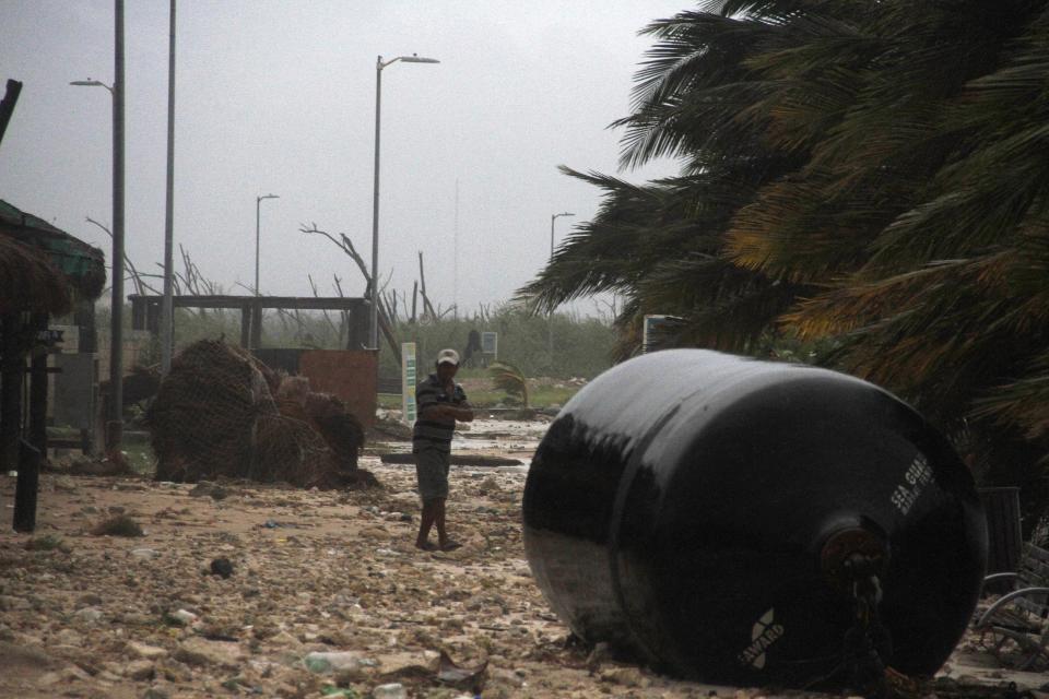 A man walks next to a marine fender that was dragged into town after it was ripped from the docks after Hurricane Ernesto made landfall overnight in Mahahual, near Chetumal, Mexico, Wednesday, Aug. 8, 2012. There were no immediate reports of storm deaths or major damage, though Ernesto ripped down billboards, toppled trees and cut electricity service as it hit the cruise ship port of Mahahual shortly before midnight Tuesday as a hurricane. Marine fenders are used to prevent naval vessels from colliding against each other or against docks, wharves and piers. (AP Photo/Israel Leal)