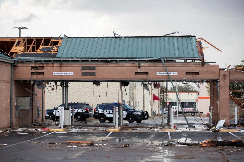 Police cars sit parked outside a bank, damaged by a tornado, near I-35 and SH 45 in Round Rock, Texas (AP)