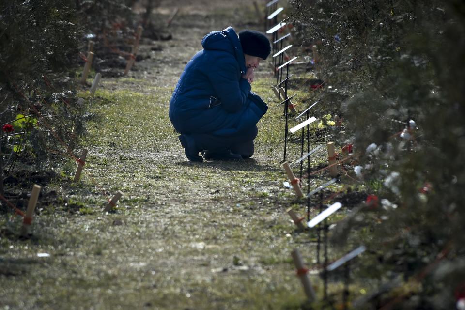 FILE - The mother of a Russian soldier who was killed in a military action in Ukraine, kneels near a planted tree in memory of her son at the Alley of Heroes in Sevastopol, Crimea, Saturday, Feb. 25, 2023. The Alley of Heroes was opened in memory of Russian servicemen who died during fighting in Ukraine. More than 70 trees were planted in the Victory Park. Nearly 50,000 Russian soldiers have died in the war in Ukraine, according to the first independent statistical analysis of Russia’s war dead. (AP Photo, File)