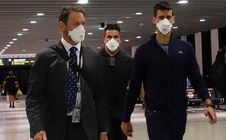 Novak Djokovic (right) at Melbourne Airport before boarding a flight out of Australia - REUTERS