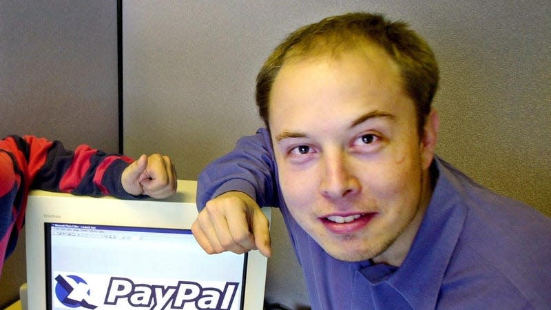 Elon Musk in a file photo from Oct. 20, 2000 posing with the PayPal logo at PayPal’s corporate headquarters in Palo Alto, Calif