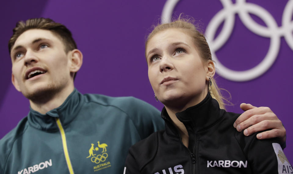 Ekaterina Alexandrovskaya and Harley Windsor of Australia watch as their scores are posted at the 2018 Winter Olympics.