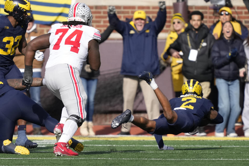 Michigan defensive back Will Johnson (2) stretches for yardage after intercepting a pass during the first half of an NCAA college football game against Ohio State, Saturday, Nov. 25, 2023, in Ann Arbor, Mich. (AP Photo/Carlos Osorio)