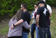 A person places an item at an entry to Covenant School which has become a memorial for shooting victims, Tuesday, March 28, 2023, in Nashville, Tenn. (AP Photo/John Amis)