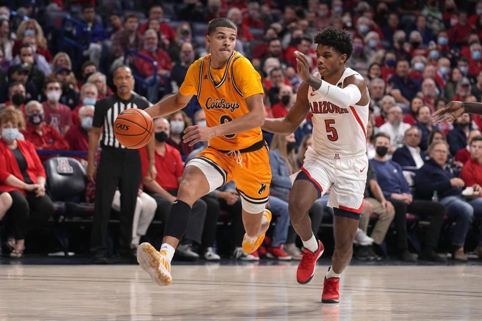 Wyoming guard Drake Jeffries (0) drives past Arizona guard Justin Kier during the first half of an NCAA college basketball game Wednesday, Dec. 8, 2021, in Tucson, Ariz. (AP Photo/Rick Scuteri)