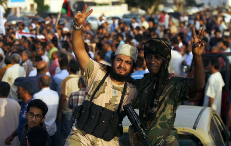 Libyan men pose for the camera during a protest against a new government proposed by UN envoy Bernardino Leon, in the eastern city of Benghazi, on October 9, 2015