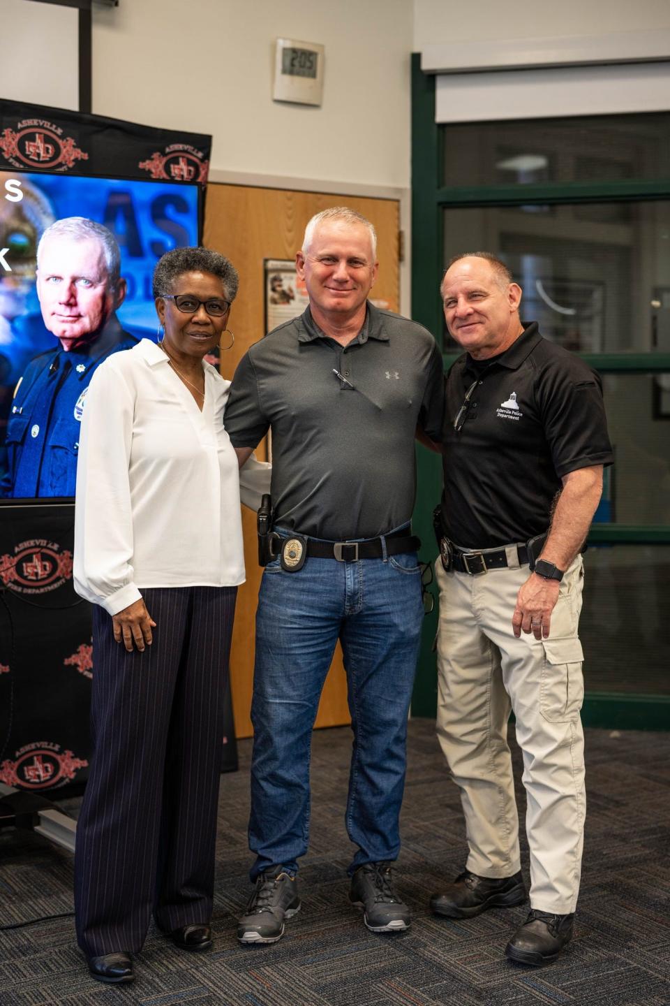 Asheville City Manager Debra Campbell, Deputy Chief James Baumstark and APD Chief David Zack pose for a picture Aug. 30, 2023, while APD officers met to celebrate Baumstark's retirement.