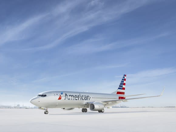 An American jet sits on an open runway.